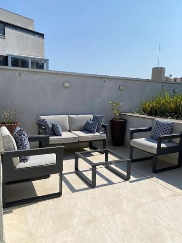 a patio with two chairs and a couch at Apartamento Espaçoso in Curitiba
