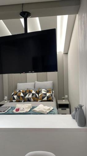a bedroom with a bed with a large monitor above it at Apartamento Espaçoso in Curitiba