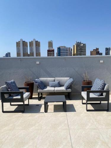 three couches and a coffee table on a patio at Apartamento Espaçoso in Curitiba