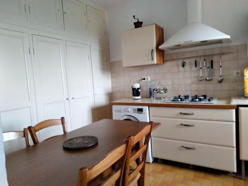 - une cuisine avec une table en bois et une cuisinière four supérieur dans l'établissement Maison de village corse, à Campitello