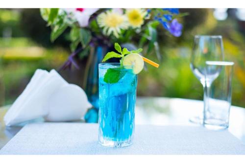 a blue drink with a lime on a table at Kongoni House in Nairobi