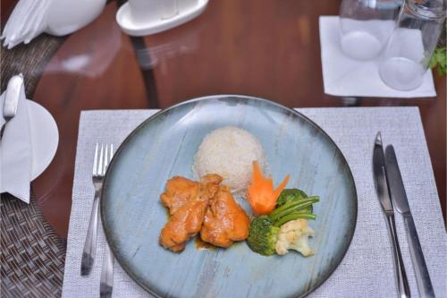 a plate of food with broccoli and rice on a table at Kongoni House in Nairobi