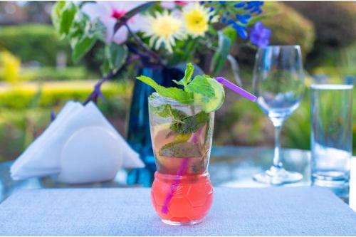 a drink in a vase on a table with a glass at Kongoni House in Nairobi
