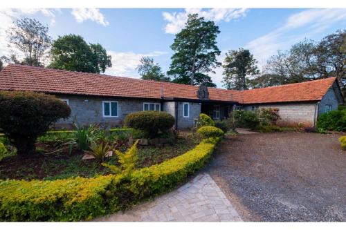 an old brick house with a garden in front of it at Kongoni House in Nairobi