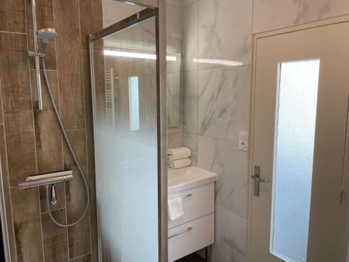 une salle de bain avec une douche, un lavabo et un miroir dans l'établissement La Caliorne, à Rennes