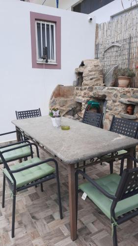 a table and chairs in front of a stone fireplace at MARINOS House WANDERN&ENTSPANNEN am Fusse des Psiloritis in Kamárai