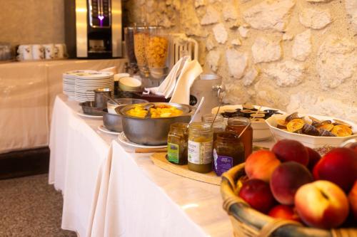 Un buffet con manzanas y otros alimentos en una mesa. en Hotel Restaurant des Thermes, en Castéra-Verduzan