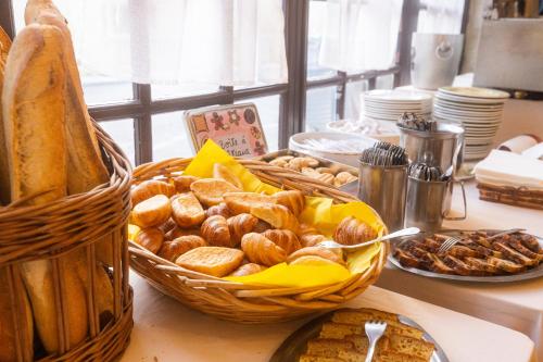 una mesa con una cesta de pan y otros alimentos en Hotel Restaurant des Thermes, en Castéra-Verduzan