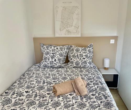 - un lit avec une couverture et des oreillers noirs et blancs dans l'établissement Appartement 2 pièces avec un jardin privatif, à Cannes