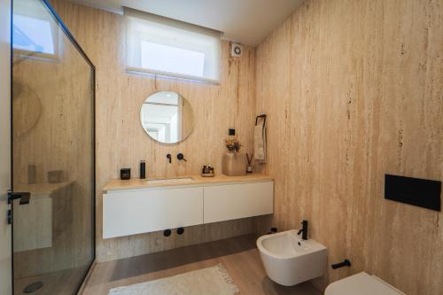 a bathroom with a sink and a toilet and a mirror at Viana Vista Villa in Viana do Castelo