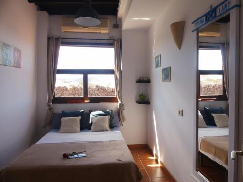 una camera da letto con due letti e due finestre di Warung a Lajares