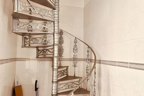 a spiral staircase in a bathroom with white tiles at 0004 - Pousada HG quarto home office single in Guarulhos