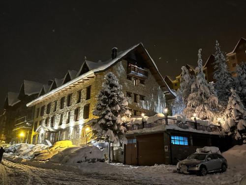 a snow covered building with a car parked in front of it at Snö Villa de Sallent 4 in Formigal