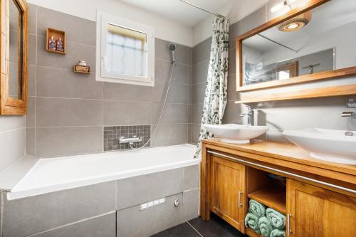 a bathroom with two sinks and a bath tub at "La scandinave" SPA et jardin luxuriant in Cers