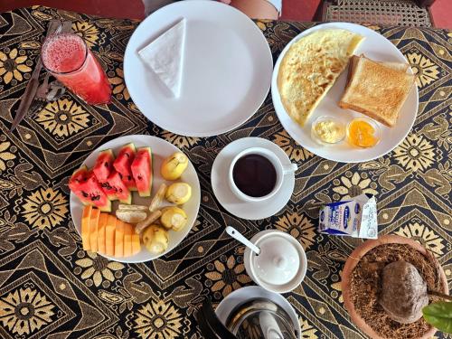 a table with two plates of food and a cup of coffee at Hanguk Villa Mirissa in Mirissa