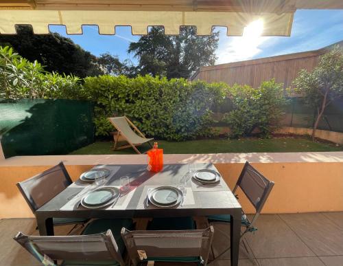 - une table et des chaises sur la terrasse dans l'établissement Appartement 2 pièces avec un jardin privatif, à Cannes