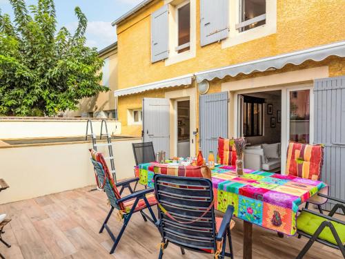 un patio avec une table et des chaises sur une terrasse dans l'établissement Holiday Home La Roue à Aubes by Interhome, à LʼIsle-sur-la-Sorgue