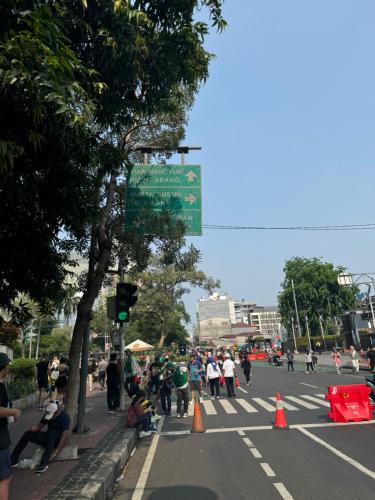 a group of people crossing a street in a city at Stunning Comfy 2BR Apartment at the Heart of Jakarta in Jakarta