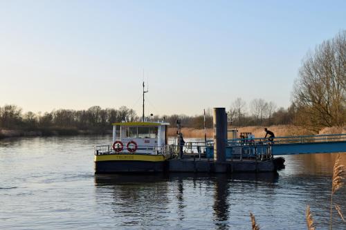 a boat is docked on a river next to a bridge at Logieslogees in Tielrode