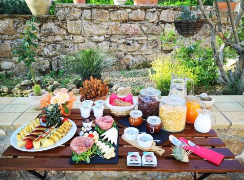 a wooden table with food and drinks on it at Panorama Suite in Piazza Armerina