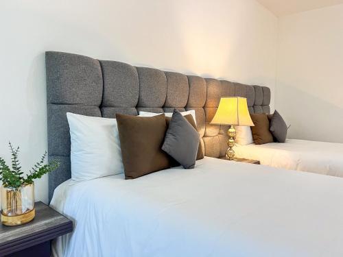 a bedroom with two beds with a large headboard at VILLAS EL ENCANTO in Jalpan