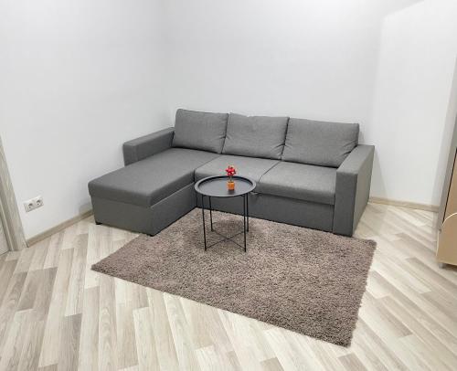 a living room with a gray couch and a table at Diamond home Apartments in Chişinău