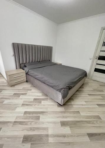 a bedroom with a bed and a wooden floor at Diamond home Apartments in Chişinău