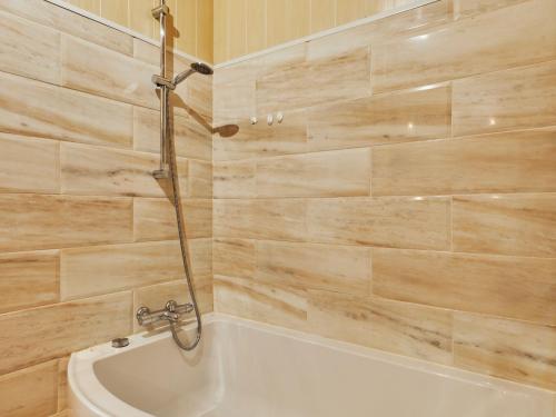 une salle de bain avec baignoire et douche dans l'établissement Holiday Home Les pieds dans l'eau by Interhome, à Quinéville