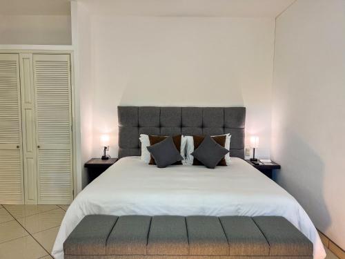 a bedroom with a large white bed with two lamps at VILLAS EL ENCANTO in Jalpan