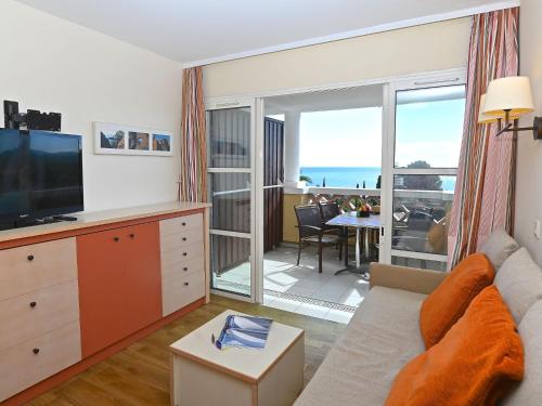 a living room with a couch and a television at Apartment Village Cap Estérel - Le Village-80 by Interhome in Agay - Saint Raphael