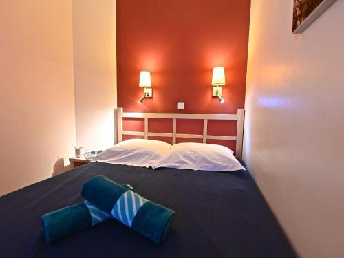 un lit avec une cravate bleue et blanche dessus dans l'établissement Apartment Village Cap Estérel - Le Village-80 by Interhome, à Agay