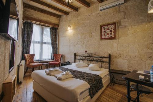a bedroom with a bed and two chairs in it at Century Cave Hotel in Goreme