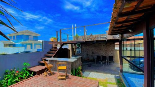 a backyard with a patio with a grill and a house at POUSADA ONDA CARIOCA in Cabo Frio
