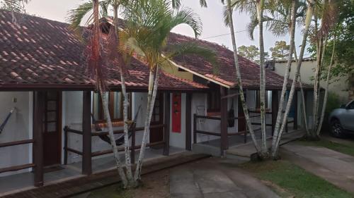 een huis met palmbomen ervoor bij Quintal da Mole in Florianópolis