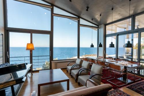 a living room with a view of the ocean at LEONIDIONHOUSES - The Lykoskufi Villas in Tiros