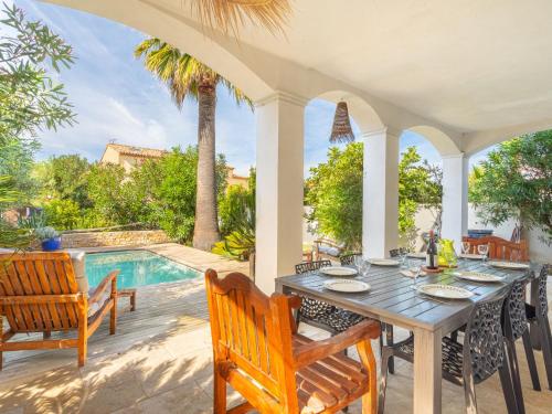 un patio avec une table et des chaises et une piscine dans l'établissement Holiday Home La maison du Port by Interhome, à Le Brusc