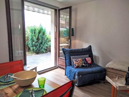 - un salon avec un canapé bleu et une porte coulissante en verre dans l'établissement Studio Les cimes blanches by Interhome, à Saint-Gervais-les-Bains