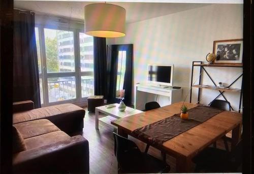 un salon avec une table en bois et un canapé dans l'établissement Chez Pascal Sissi -Grand Appart,Ile Nantes, CCgrés, à Nantes