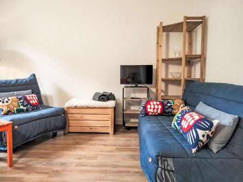 - un salon avec deux canapés bleus et une télévision dans l'établissement Studio Les cimes blanches by Interhome, à Saint-Gervais-les-Bains