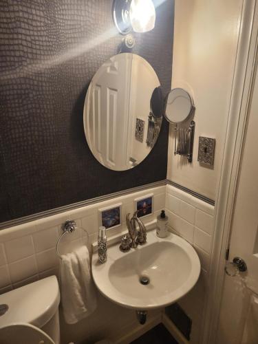 a bathroom with a sink and a mirror and a toilet at Amazing DC Home Away From Home in Washington, D.C.
