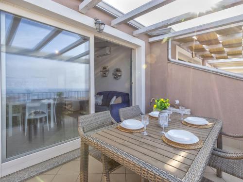 a dining table and chairs on a balcony at Apartment Attico Vista Isola by Interhome in Trinità dʼAgultu