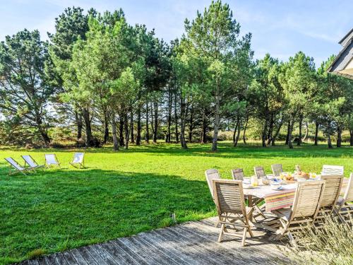 a table and chairs in a field with trees at Holiday Home Le Prado-3 by Interhome in Saint-Philibert