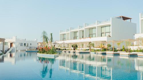 a pool of water in front of a building at Mykonos Homes - Stilvolles Apartment mit eigenem Jaccuzzi in Bahçeli
