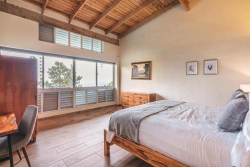 a bedroom with a bed and a desk and a window at Majestic villa with stunning views in Jarabacoa in Buena Vista