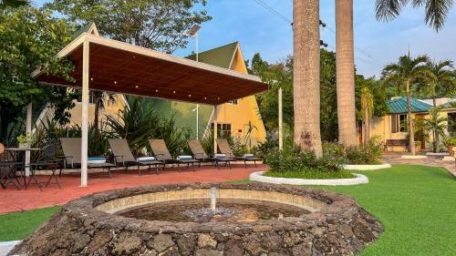 a fountain in a yard with chairs and a table at VILLAS EL ENCANTO in Jalpan