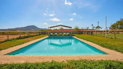 a large swimming pool in a field with a fence at Luxurious Villa in Prado del Rey with Pool in Prado del Rey