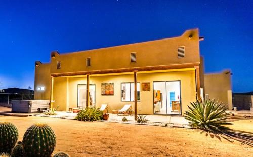a house in the desert with cacti in front of it at Desert Retreat w/ Spa+Views in Joshua Tree