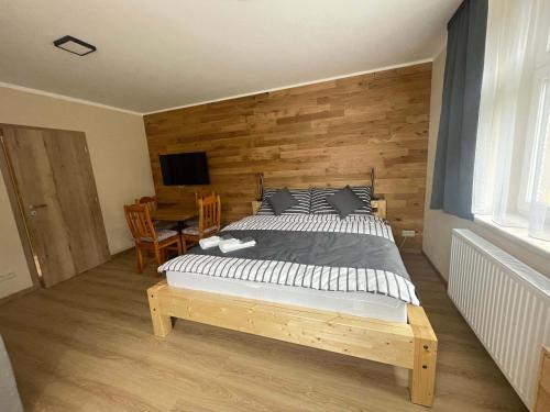a bedroom with a bed and a wooden wall at Apartmány U Bernharda in Vítkov