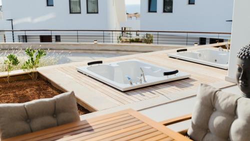 a bath tub on a deck with two sinks at Mykonos Homes - Stilvolles Apartment mit eigenem Jaccuzzi in Bahçeli