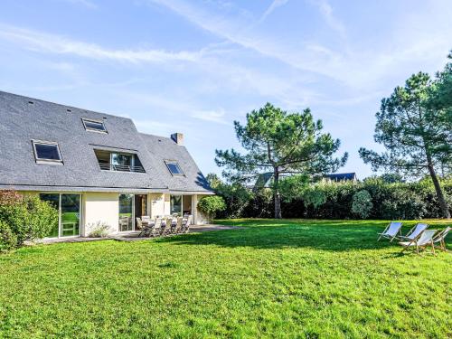 a yard with chairs and a house at Holiday Home Le Prado-1 by Interhome in Saint-Philibert